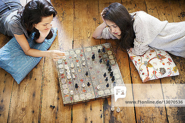 High angle view of sisters playing chess at home