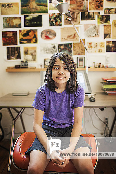 Porträt eines lächelnden Mädchens  das auf einem Sitz zu Hause sitzt