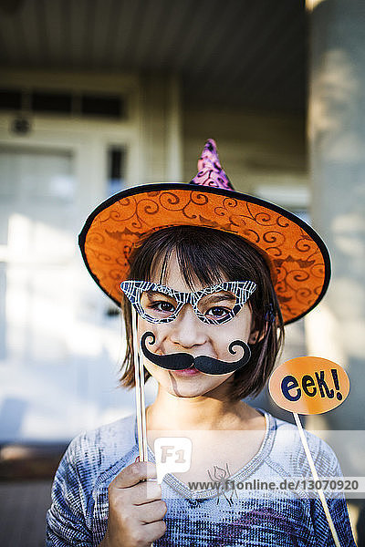 Porträt eines lächelnden Mädchens mit Requisiten während der Halloween-Party