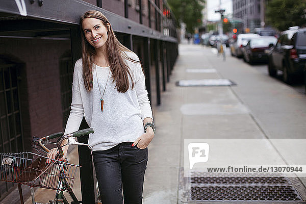 Frau schaut weg  während sie mit dem Fahrrad an der Straße steht