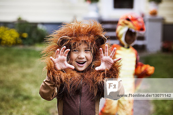 Porträt eines Mädchens in Halloween-Kostüm  das sich im Hof mit einem Freund im Hintergrund vergnügt