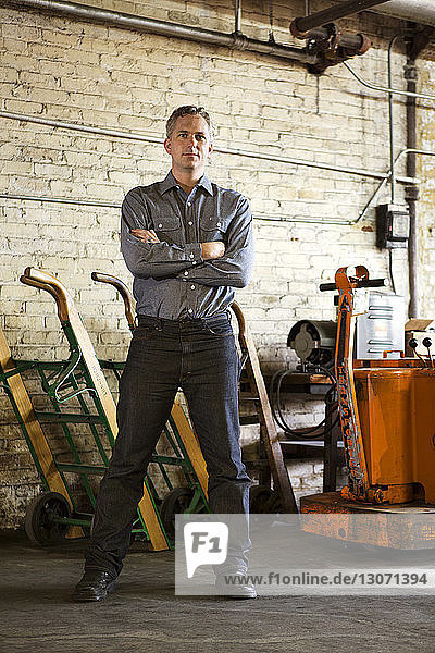 Portrait of confident businessman standing in factory