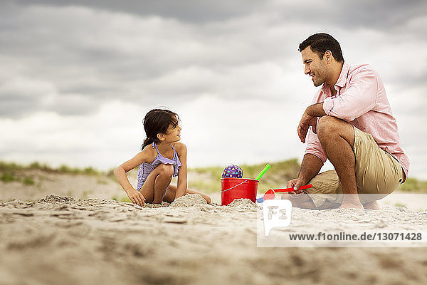 Surface level of father playing with daughter at beach