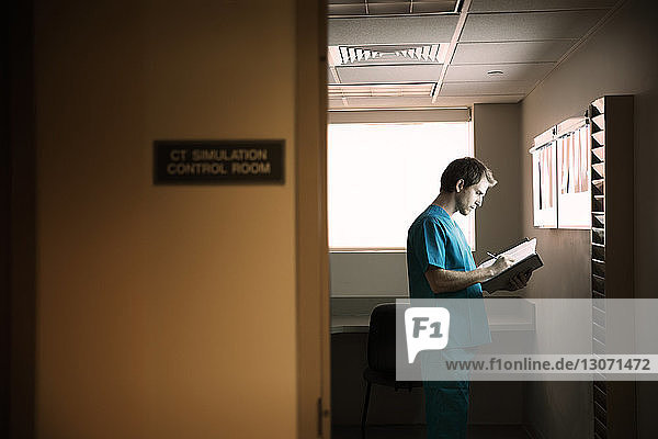Arzt liest Berichte im Stehen auf der Krankenhausstation