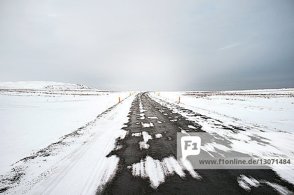 Szenische Ansicht der Straße inmitten eines schneebedeckten Feldes