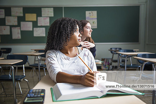 Schüler schauen weg  während sie im Klassenzimmer sitzen