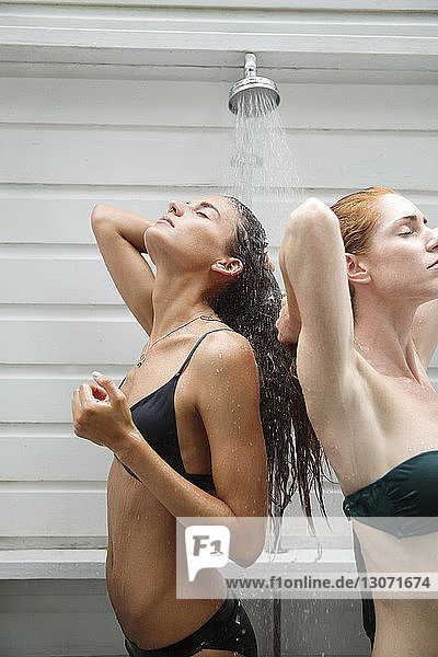 Women in bikini taking shower