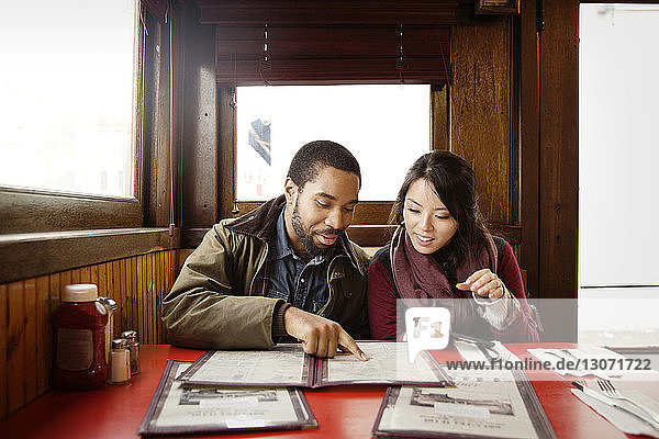 Couple looking at menu while sitting in restaurant