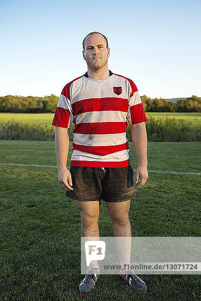 Porträt eines Rugby-Spielers in voller Länge  der auf einem Rasenfeld steht