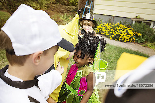 Kinder in Halloween-Kostümen genießen im Hof