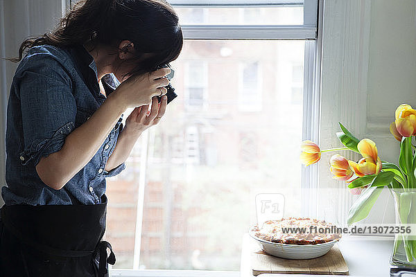 Frau fotografiert gebackenen Kuchen
