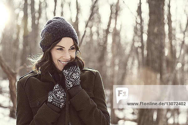 Happy woman looking away in forest