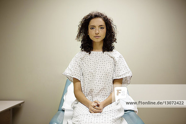 Portrait of woman sitting on bed in hospital