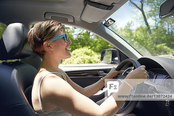 Side view of woman driving car