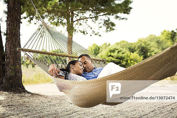 Couple relaxing on hammock in backyard