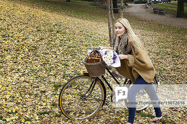 Frau mit Fahrrad auf dem Feld
