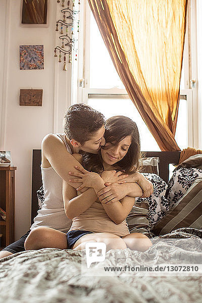 Lesben  die zu Hause im Bett sitzen und sich romantisch unterhalten