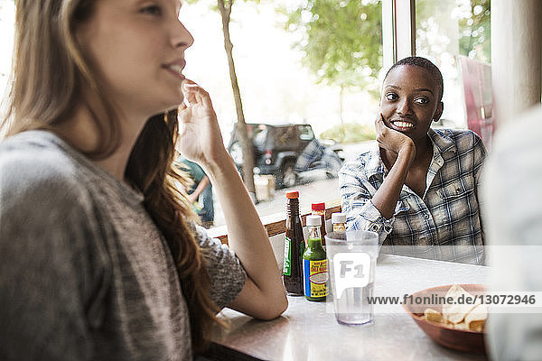Freunde schauen Freunde an  während sie im Restaurant sitzen