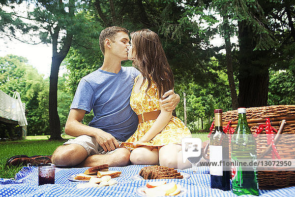 Paar küsst sich im Park sitzend
