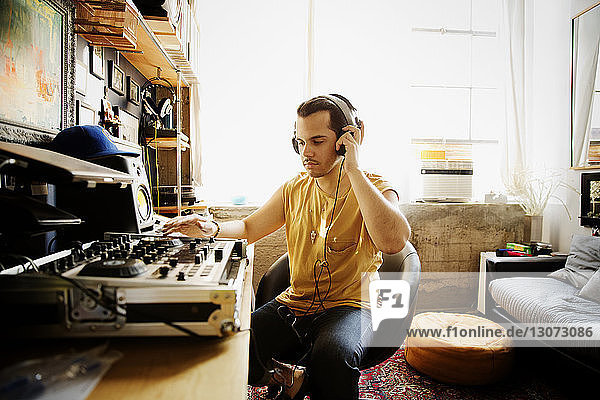 Serious DJ playing sound mixer at recording studio