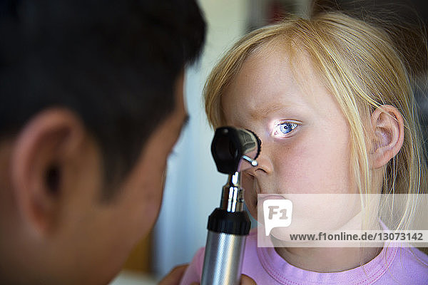 Arzt prüft das Auge des Mädchens