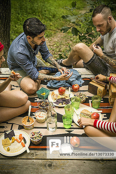 High angle view of friends eating food in forest