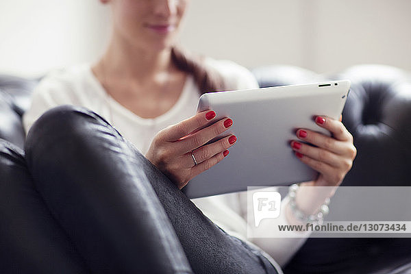 Ausgeschnittenes Bild einer Frau  die zu Hause einen Tablet-Computer benutzt