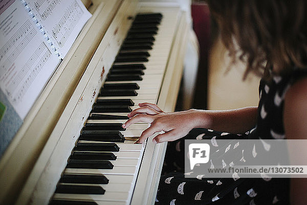 Hochwinkelaufnahme eines zu Hause Klavier spielenden Mädchens