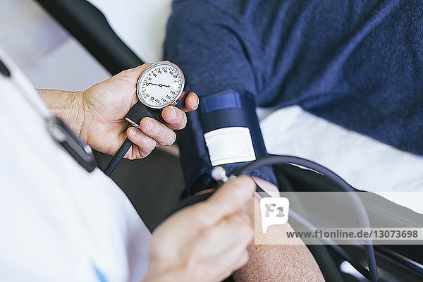 Close-up of doctor checking patient blood pressure at hospital