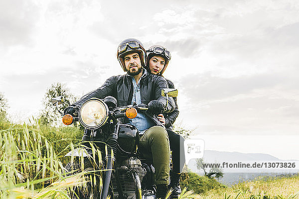 Porträt eines auf einem Motorrad sitzenden Paares gegen den Himmel