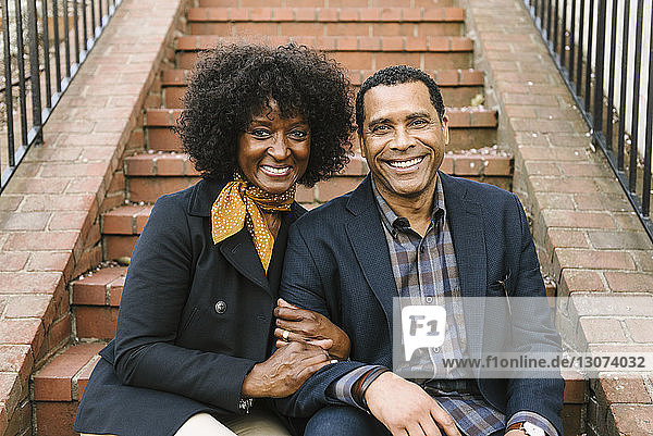 Porträt eines glücklichen Paares auf einer Treppe sitzend
