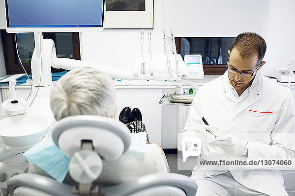 Zahnarzt im Gespräch mit Patientin in der Klinik