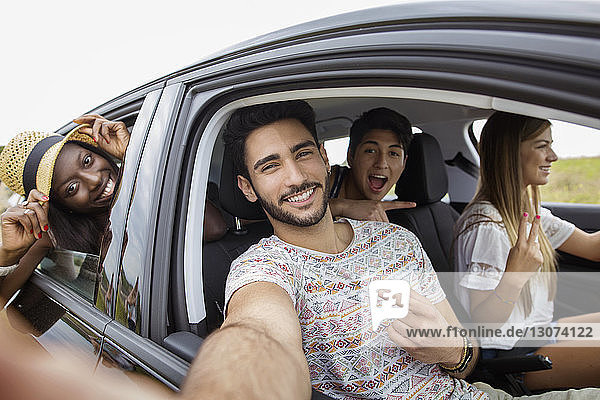 Portrait of cheerful friends on road trip