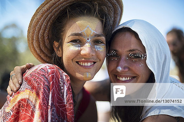 Porträt von lächelnden Freunden mit Gesichtsbemalung bei traditioneller Veranstaltung