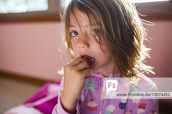 Portrait of girl touching tooth at home