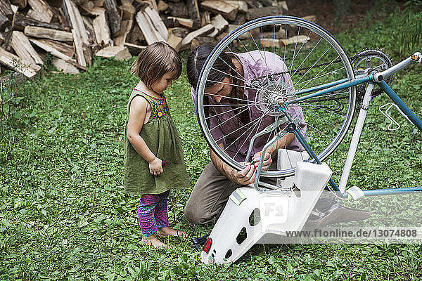 Vater bindet für Tochter im Hinterhof Stuhl an Fahrrad