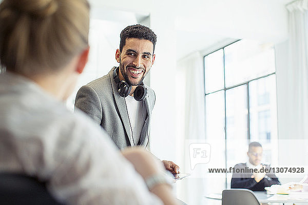 Happy colleagues talking in office