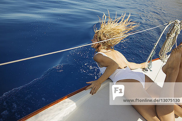 Full length of mid adult woman lying on yacht
