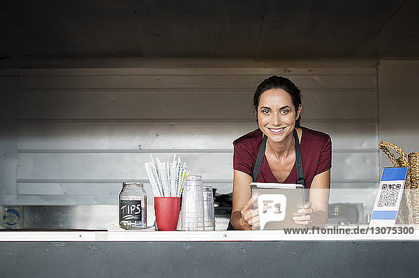 Portrait of female vendor with tablet computer in food truck