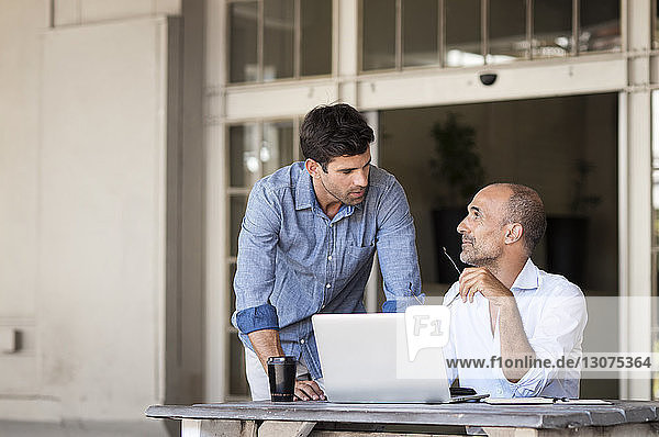Business people discussing while sitting at table in office