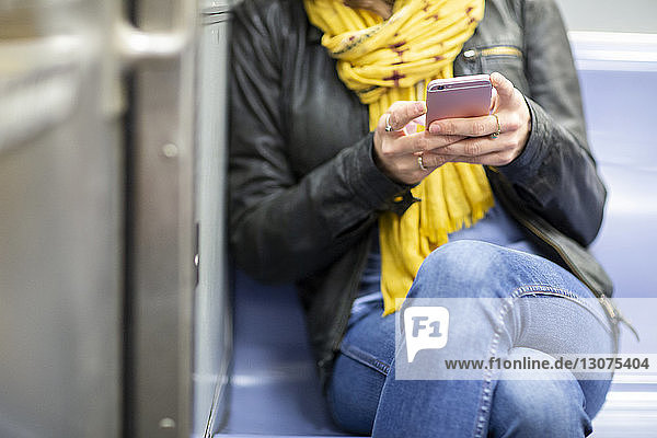 Ein Teil der Frau benutzt ein Smartphone während einer Zugfahrt