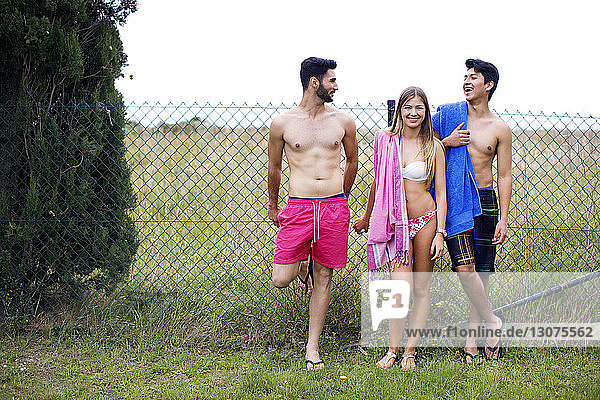 Glückliche Freunde in Badebekleidung stehen auf dem Hof