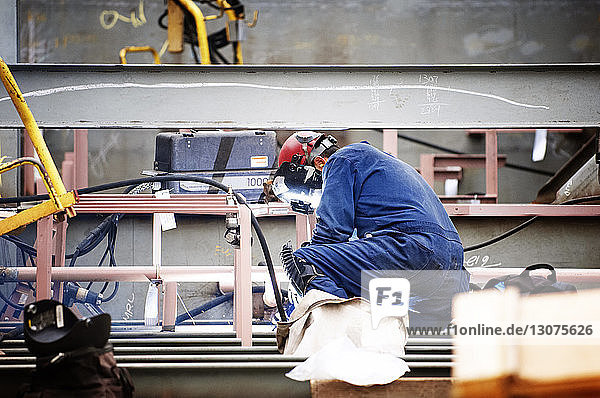 Side view of worker working at shipyard
