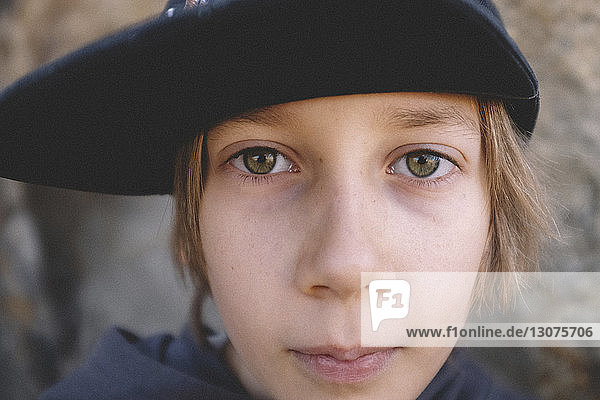 Close-up portrait of confident boy wearing cap at desert