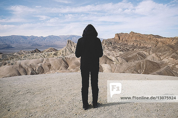 Rückansicht eines Mannes  der im Death Valley National Park auf einem Berg gegen den Himmel steht
