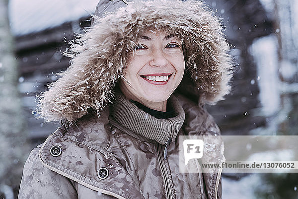 Nahaufnahme einer glücklichen Frau  die bei Schneefall im Freien steht