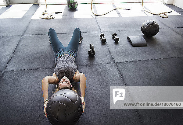 Focused athlete exercising with medicine ball in crossfit gym
