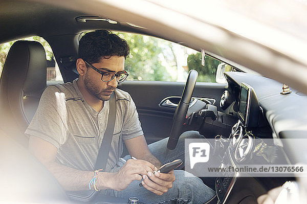 Man using mobile phone while sitting in car