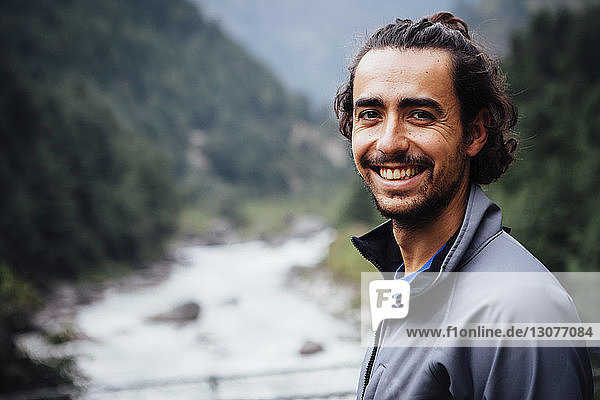 Nahaufnahme eines lächelnden Mannes  der am Fluss im Sagarmatha-Nationalpark steht