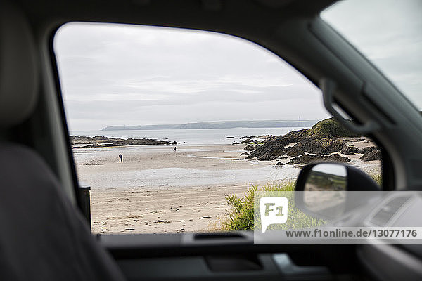 Scenic view of sea against cloudy sky seen through motor home window